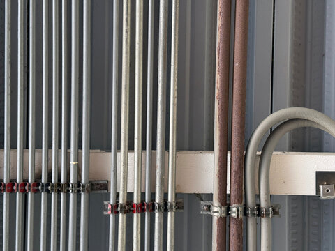 Industrial metal pipes and electrical conduits on wall