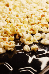 Close-up of fresh popcorn on a black baking tray