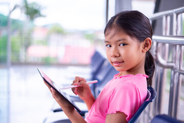 Smiling Young Girl Using Stylus on Digital Tablet in Modern