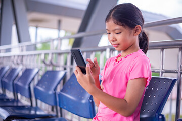Young Girl Using Smartphone While Sitting in Public Area