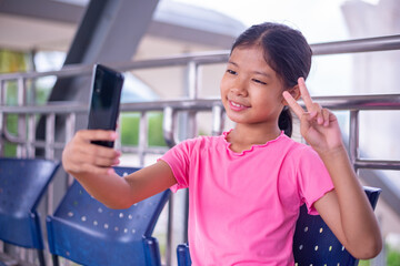 Asian girl using Tablet or Laptop Computer Device with Cloud Computing for Distant Learning or Remote Communication.