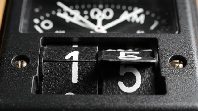 Close up of a vintage flip clock showing time 1 -17 AM.