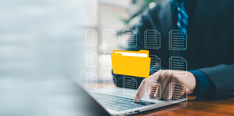 A business professional accessing a digital yellow folder on a laptop, representing file...