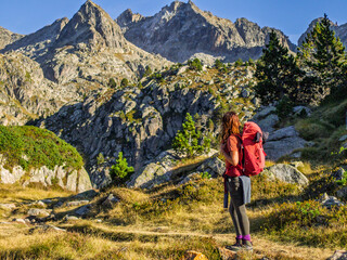 Naklejka premium Hiker observing the Saboredo cirque, Rue Valley, Aigüestortes National Park, Alto Arán, Lleida, Catalonia, Spain