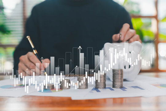 A professional analyzing savings and financial growth with stacked coins, charts, and virtual data graphics, symbolizing investment planning, money management, and long-term financial strategy. - Powered by Adobe