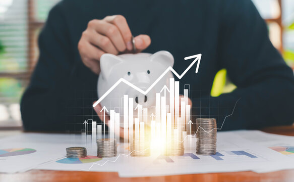 A person saving money into a piggy bank with stacked coins and virtual financial growth charts, symbolizing savings growth, investment planning, wealth management, and long-term financial strategy.