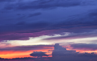 Enchanted sunset sky painted with luminous colors behind drifting clouds