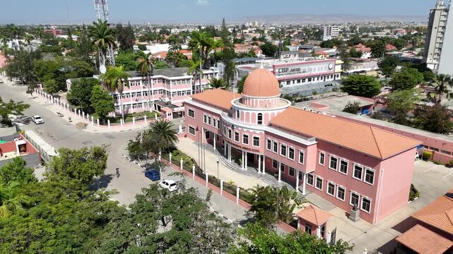 Aerial drone footage of Benguela city, Angola, highlighting pastel colonial architecture, palm trees, and streets close to the Atlantic seafront
