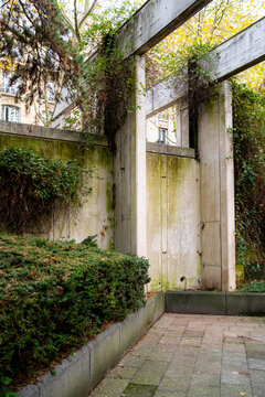 Concrete geometry guiding an autumn garden pathway with vegetation arranged through landscape design principles in a calm urban park atmosphere with no people
