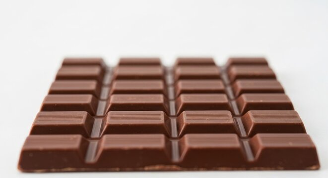 Rectangular milk chocolate bar with segmented blocks, crisp edges, light background