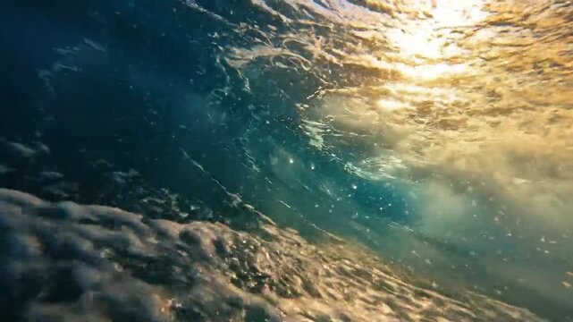 Underwater view of ocean waves with sunlight, beautiful water texture.