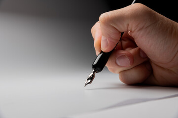 hand writes with a black pen on a clean white background with ample space for text. The hands masterfully practiced calligraphy on textured paper, surrounded by a serene atmosphere