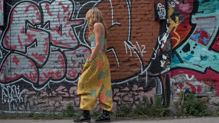 Bohemian fashion video featuring young woman dancing with graffiti art in urban scene, vibrant energy and movement - Powered by Adobe