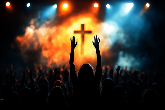 people raising their hands in worship at a church, with a cross on the stage background