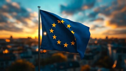 European Union flag waving at sunset. The European Union flag displays proudly against a vibrant sunset with clouds and city skyline in the background.