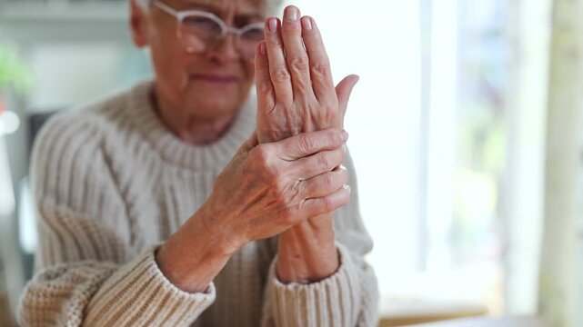 Senior woman with arthritis rubbing hands
