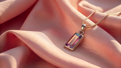 A bar shaped alexandrite pendant stone placed on coral pink linen warm sunlight creating gentle pastel highlights