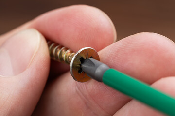 Hand of the worker and screw close up