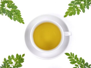 Moringa tea (moringa oleifera) in cup on white background. Herbal drink for health. Flat lay 