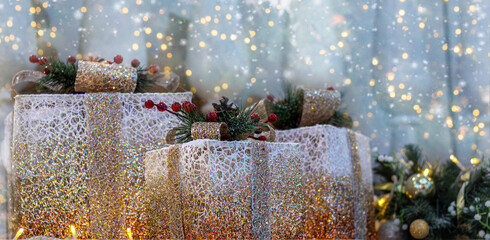 Festive banner with beautifully wrapped glowing Christmas gifts decorated with pine cones and red berries. Space for copy, for text.