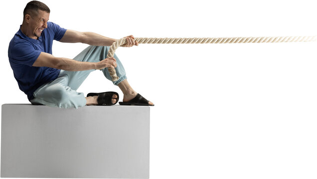 Man sitting on block pulling heavy rope with intense emotional effort on transparent background. Concept of struggle, determination, business pressure, teamwork metaphors and motivational visuals. - Powered by Adobe