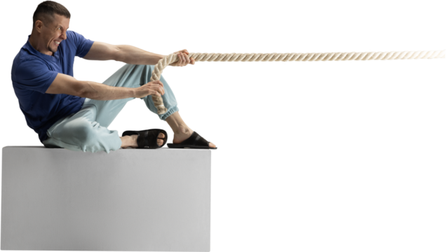 Man sitting on block pulling heavy rope with intense emotional effort on transparent background. Concept of struggle, determination, business pressure, teamwork metaphors and motivational visuals.
