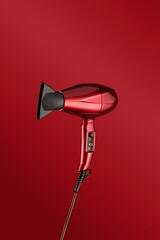 Red glossy hair dryer on a red background