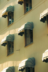 Striped awnings casting shadows on a classic urban facade