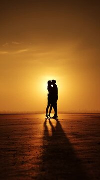 paar amn strand im sonneuntergang gibt sich einen kuss