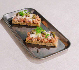 Delicious spread on toasted bread served on metal tray in a cozy setting