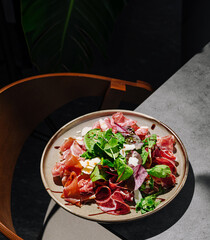 Colorful salad with various meats and greens served on a plate