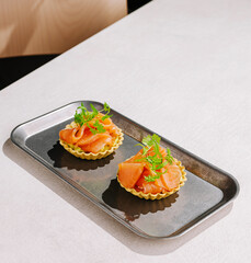 Delicious seafood tartlets served on a sleek metallic tray in a modern setting