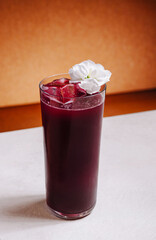 Refreshing drink with flower garnish in a glass on a light background