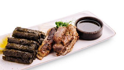 Delicious international dish featuring grilled meat and stuffed grape leaves