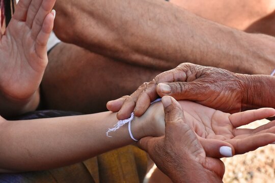 Binding people&rsquo;s wrist. Which is a ritual of Thai people's belief.
