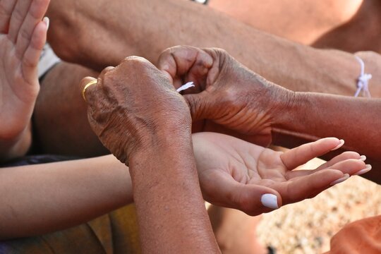 Binding people&rsquo;s wrist. Which is a ritual of Thai people's belief. 