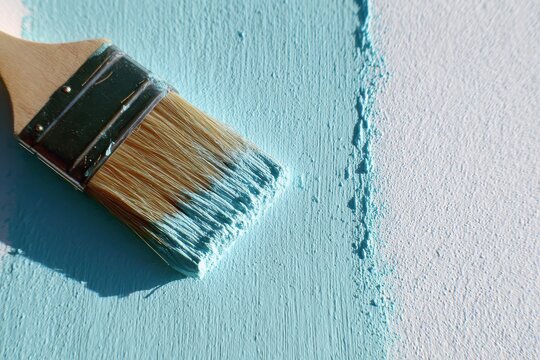 Minimalist turquoise paint streak with brush on white background