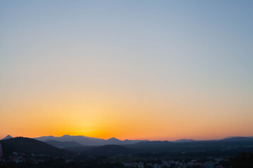 Golden morning sunrise illuminates the mountain horizon, casting warm light over peaceful peaks and valleys. Serene, atmospheric landscape with a calm and inspiring dawn mood.50 Keywords: