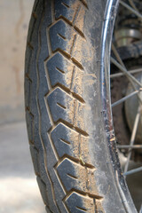 Vertical grunge image of a dirty motorbike tire covered in mud. For graphic design, 3D rendering and banners
