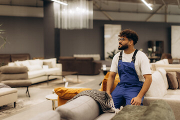 Obraz premium Young man worker in furniture showroom thinking