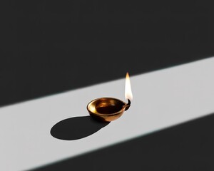 Lit Brass Diya Oil Lamp Casting a Shadow on a Striped Surface ancient candle