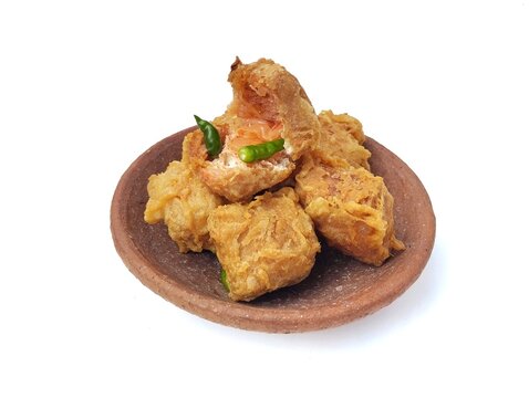 Gehu or Indonesian food made from fried tofu filled with bean sprouts and spices on plate isolated on white background. High angle view