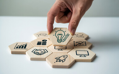 Hand placing a lightbulb icon on a wooden hexagon puzzle symbolizing creative ideas and innovative solutions for business growth and strategic planning on a white surface