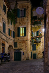 Medieval narrow street in Siena at night, Tuscany, Italy. Architecture and landmark of Siena. Cozy cityscape of Siena