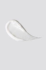 Swatch of white cream on white background, top view