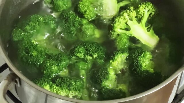 Fresh broccoli branches during cooking in stainless steel pot
