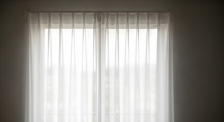 Sheer white curtains covering window letting in soft natural light indoors