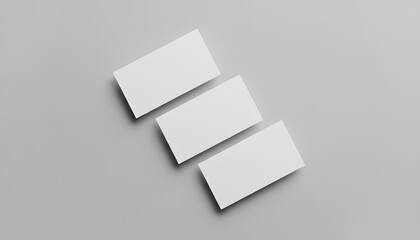 Top view of three blank white business cards mockup on a grey background