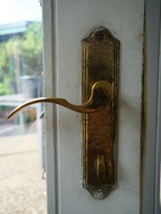 Vintage brass window handle showing weathered patina detail