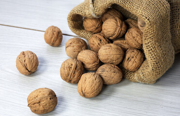 walnuts in a wicker bag on rustic wood